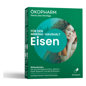 Packung für Nahrungsergänzungsmittel mit Eisen, grün, enthält Vitamin C, Kupfer und B-Vitamine, abgebildete Frau im Hintergrund.