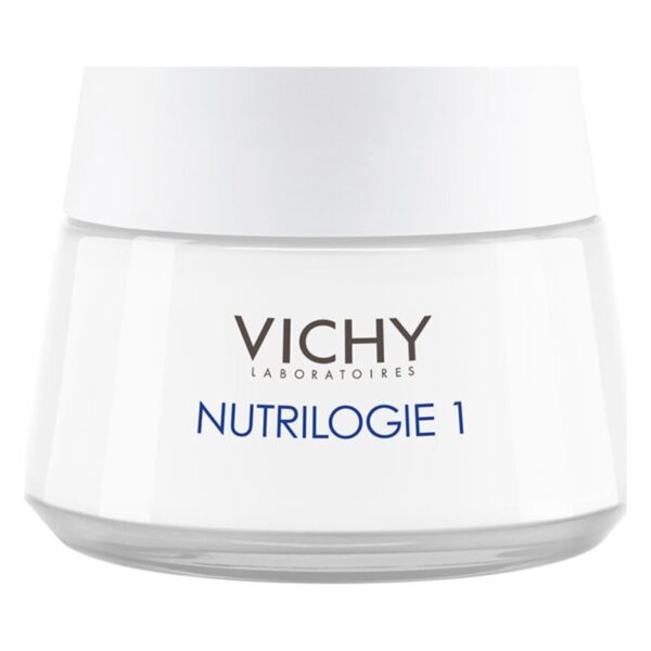 Eine weiße Creme in einem Glasbehälter mit einem grauen Deckel, gekennzeichnet mit "VICHY NUTRILOGIE 1".