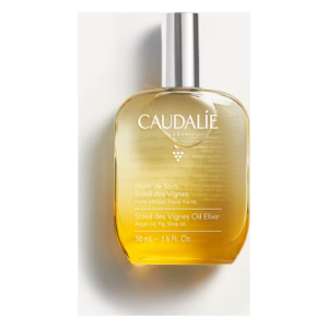 Glasflasche mit einem goldenen Öl und silbernem Deckel, beschriftet mit "Huile de Soin Soleil des Vignes" von Caudalie.