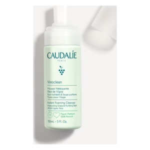 Flasche mit schaumiger Reinigungsmousse von Caudalie, grün mit weißen Details, für alle Hauttypen geeignet.
