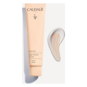 Röhrenförmige Verpackung einer getönten Creme von Caudalie mit Produktname und einer Farbprobe daneben.