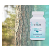 Weißes Fläschchen mit der Aufschrift "EYKÄR EYE THERAPY GLAUKOM Hochdruck" vor unscharfem Baumhintergrund.