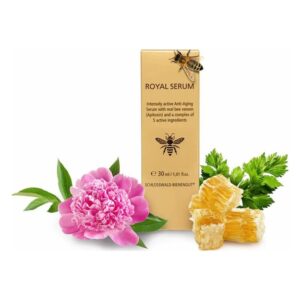 Eine goldene Verpackung des Royal Serums umgeben von Blüten und Bienenwachs, das Anti-Aging-Eigenschaften hervorhebt.